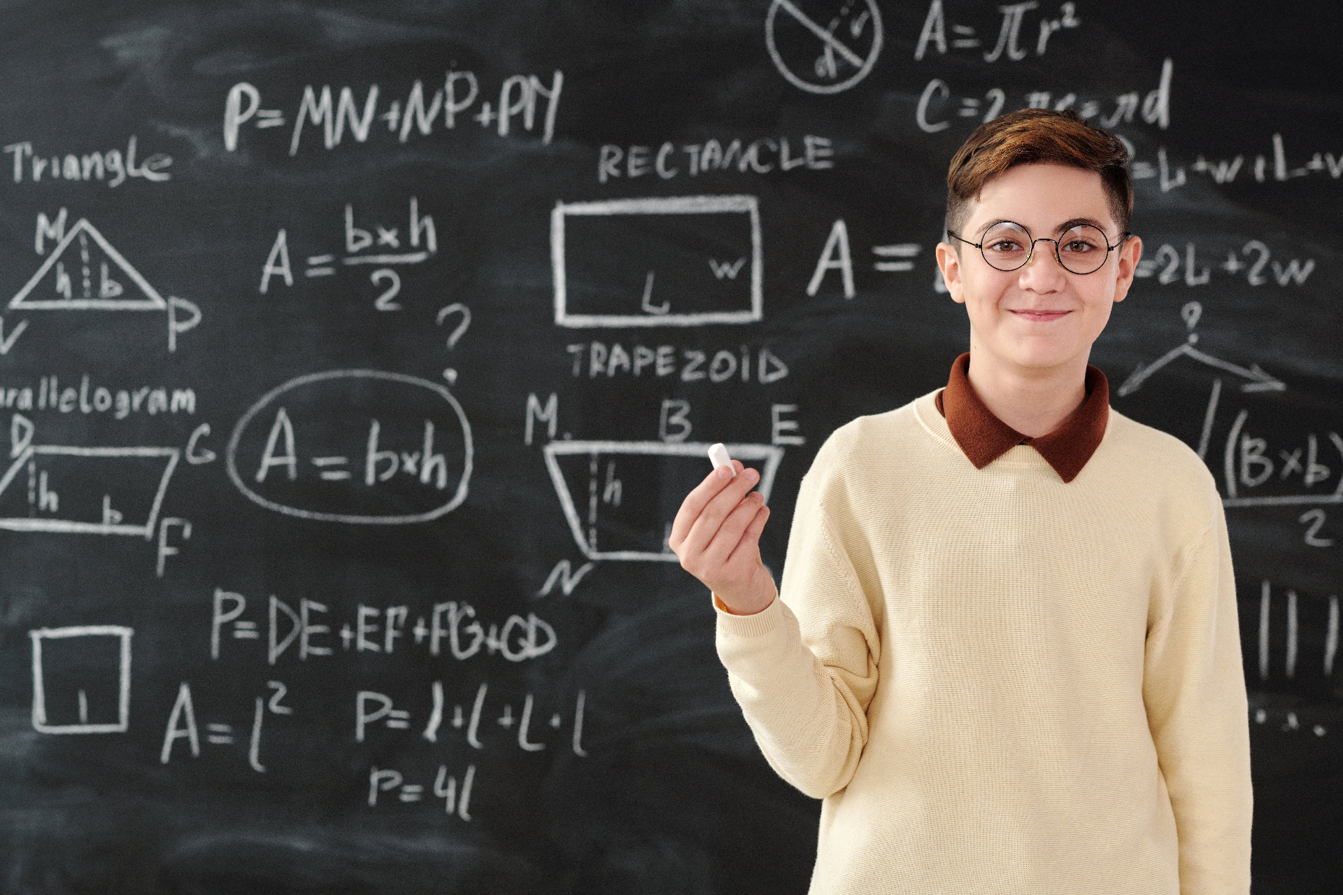 Uczeń przy tablicy z figurami geometrycznymi